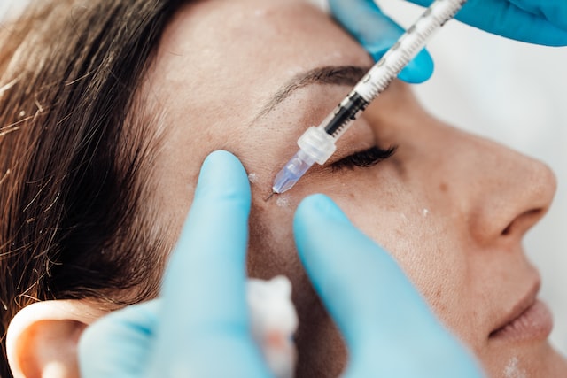 attractive blond woman is getting a facial injections