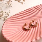 gold and silver earrings on pink