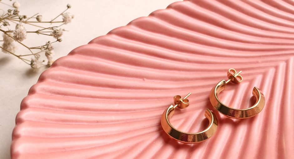 gold and silver earrings on pink
