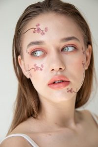 woman with pink and white floral face paint